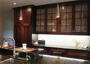 Dark-stained kitchen with a floor-to-ceiling pantry and divided-lite glass uppers